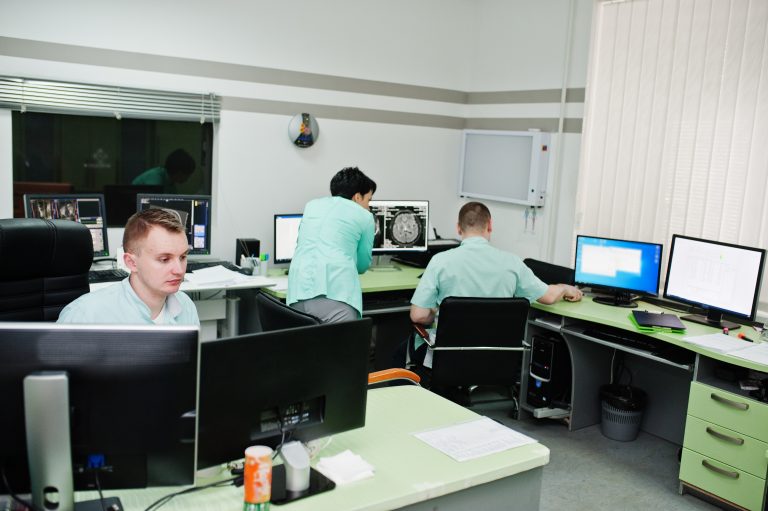 Medical theme.Observation room with a computer tomograph. The group of doctors meeting in the mri office at diagnostic center in hospital.