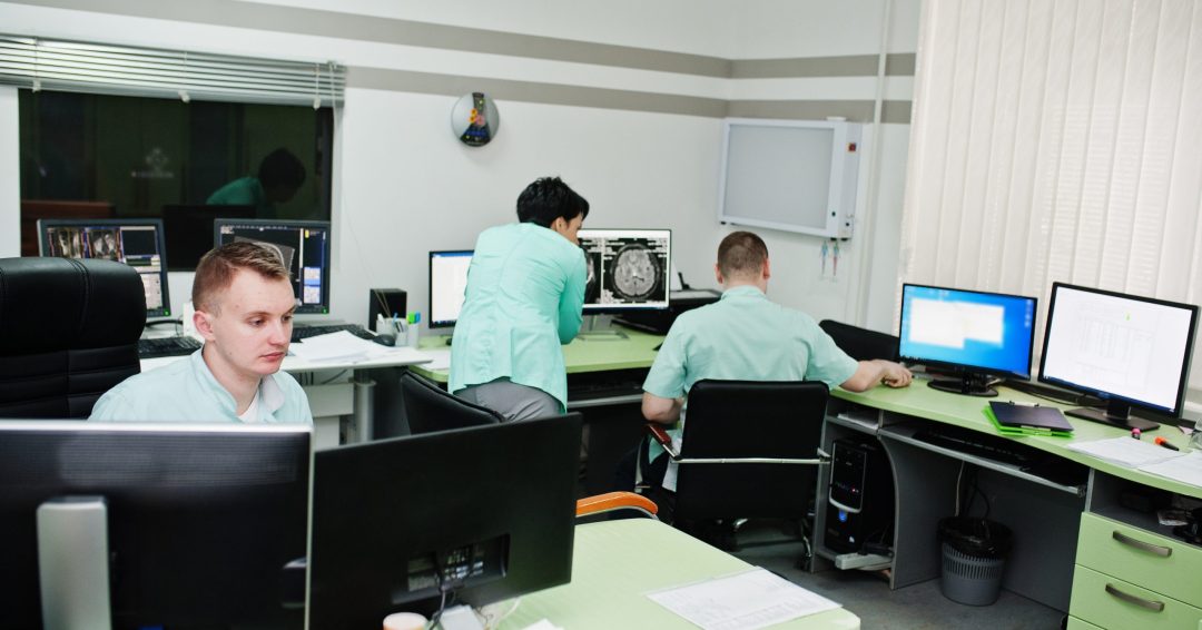 Medical theme.Observation room with a computer tomograph. The group of doctors meeting in the mri office at diagnostic center in hospital.