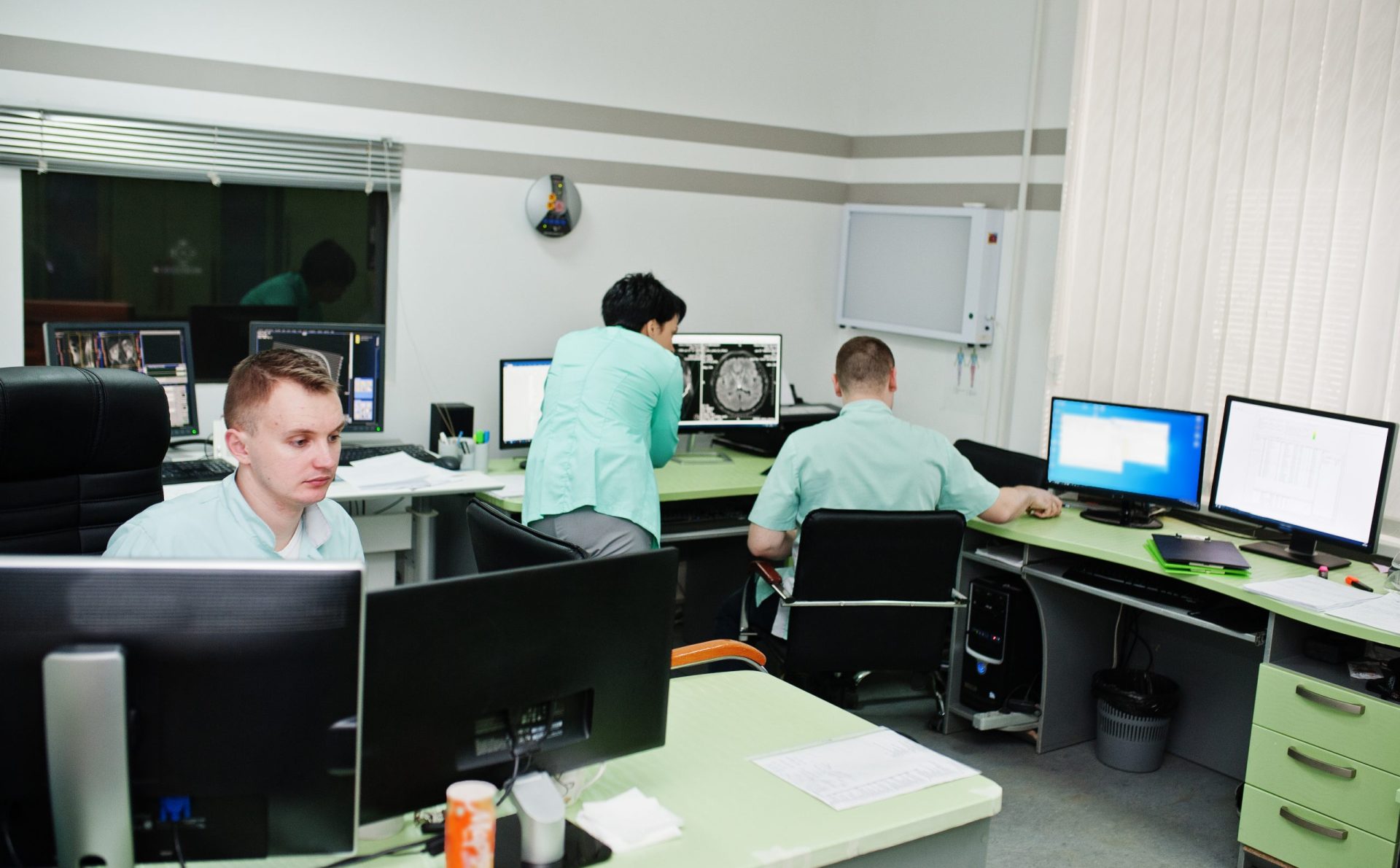 Medical theme.Observation room with a computer tomograph. The group of doctors meeting in the mri office at diagnostic center in hospital.